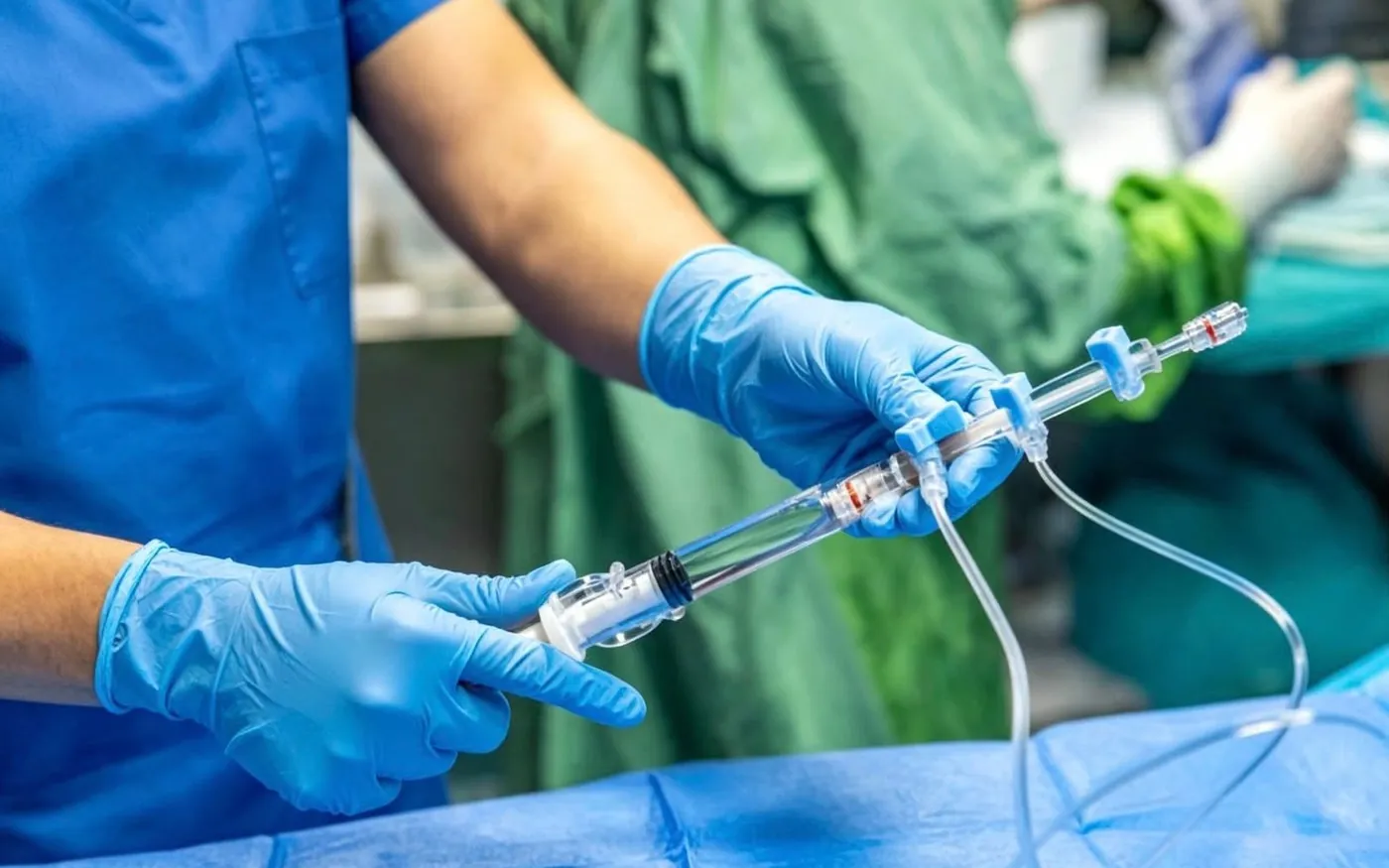 A clinician in gloves handling a sealed dialyser before use